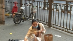 2020年6月14日,北京疫情再起。安徽进京创业的张女士业余时间在街头卖手机配件,因生意不好提前收摊。(美国之音叶兵拍摄)