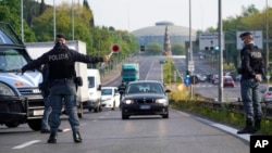 意大利罗马的警察在通往城市主干道上叫停车辆。(2020年4月13日)