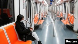 意大利首都罗马,一名戴着防护口罩的妇女坐在空荡的地铁里,这是意大利政府为减缓新冠病毒蔓延而实施史无前例封锁的第三天。(2020年3月12日)