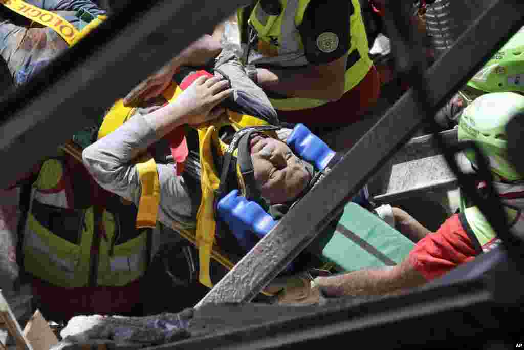 A man is rescued from the rubble of a building after an earthquake, in Accumoli, central Italy, Aug. 24, 2016.  Rescue crews race to dig survivors out of the rubble, but the toll was expected to rise as crews reached homes in more remote hamlets.