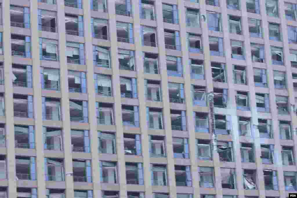 天津爆炸事故现场,核心爆炸区周围多座居民楼窗户被震碎,高速公路桥梁受损,多辆大货车被炸翻,小汽车起火或被砸,多名当地居民仍逗留在事故现场。(美国之音记者东方拍摄)