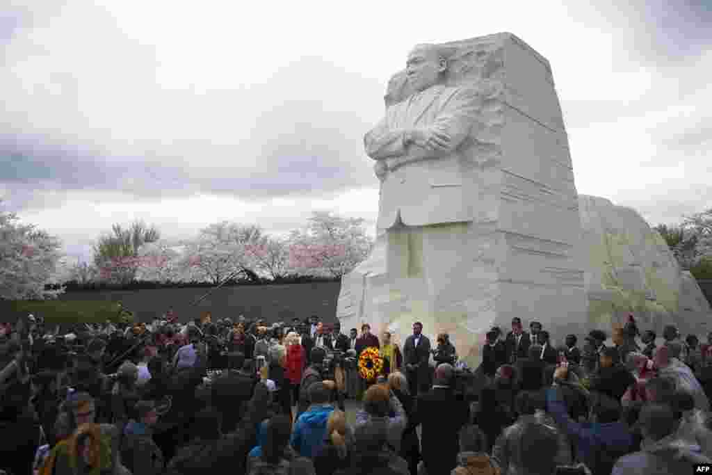2018年4月4日,华盛顿特区,马丁·路德·金纪念园, 一座高9米的马丁路德金雕像之下,人们集会纪念Martin Luther King Jr.牧师遇刺50周年。时值樱花季节。马丁路德金雕像由中国雕刻家雷宜锌制作, 这是中国人首次完成如此重要的美国领袖人物的大型雕塑作品。 雕像上,马丁.路德.金从巨石中出现,表情凝重,双臂交叉,左手紧握文稿。