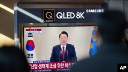 资料照片:韩国首尔火车站正在播放韩国总统尹锡悦的电视讲话。(2024年12月12日)
