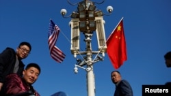 资料照:2017年11月8日,美国前总统特朗普访问北京之前,北京天安门广场灯柱上悬挂起美中国旗。