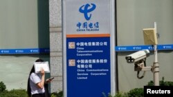 一名女子走过北京的中国电信办公楼。(路透社2020年8月11日)