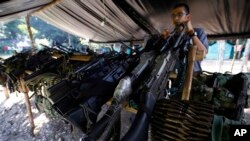 FILE - Weapons belonging to rebels of the Revolutionary Armed Forces of Colombia (FARC) are stored at a rebel camp in La Carmelita near Puerto Asis in Colombia's southwestern state of Putumayo.