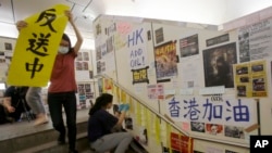 在台湾的香港学生为执行当地政府的指令从一面连侬墙上移走标语。(2019年8月31日)