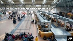 Penumpang berdiri di depan konter di Bandara Hamburg, Jerman, 9 Maret 2025 di tengah aksi mogok yang memaksa pembatalan penerbangan.