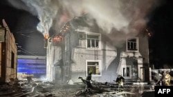 乌克兰紧急服务部门发布照片显示,救援人员正在扑灭基辅遭无人机袭击的一座行政大楼的大火。(2024年1月30日)