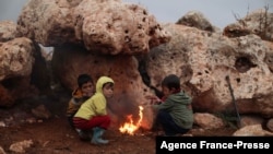 在叙利亚西北部叛军控制的伊德利卜省达纳镇一处难民营,因战乱流离失所的孩子们聚集在篝火旁取暖。(2021年11月20日)