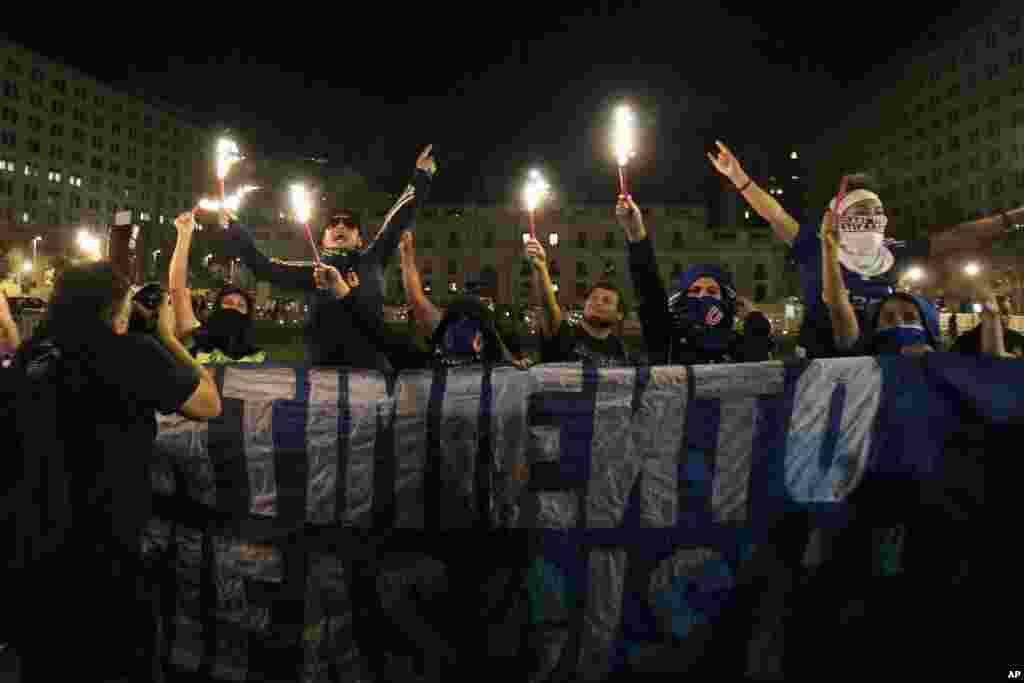 Some protesters, hold torches in front of La Moneda palace, during a march ahead of International Women's Day in Santiago, Chile, March 6, 2015.