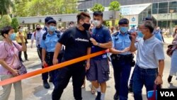 有支持及反对白衣人的市民,7月22日首宗7-21暴动案判刑后在法院大楼外互相指骂,警方围起封锁线分隔 (美国之音/汤惠芸)