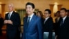 Japanese Prime Minister Shinzo Abe, center, tours the John F. Kennedy Presidential Library in Boston, with Edwin Schlossberg, left, and Caroline Kennedy, background center, Sunday, April 26, 2015.