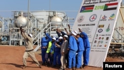 资料照片:工人们在南苏丹团结油田原油泵送重启仪式上留影。(2019年1月21日)