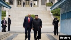 美国总统特朗普与朝鲜领导人金正恩站在板门店分割朝韩的军事分界线上(2019年6月30日)