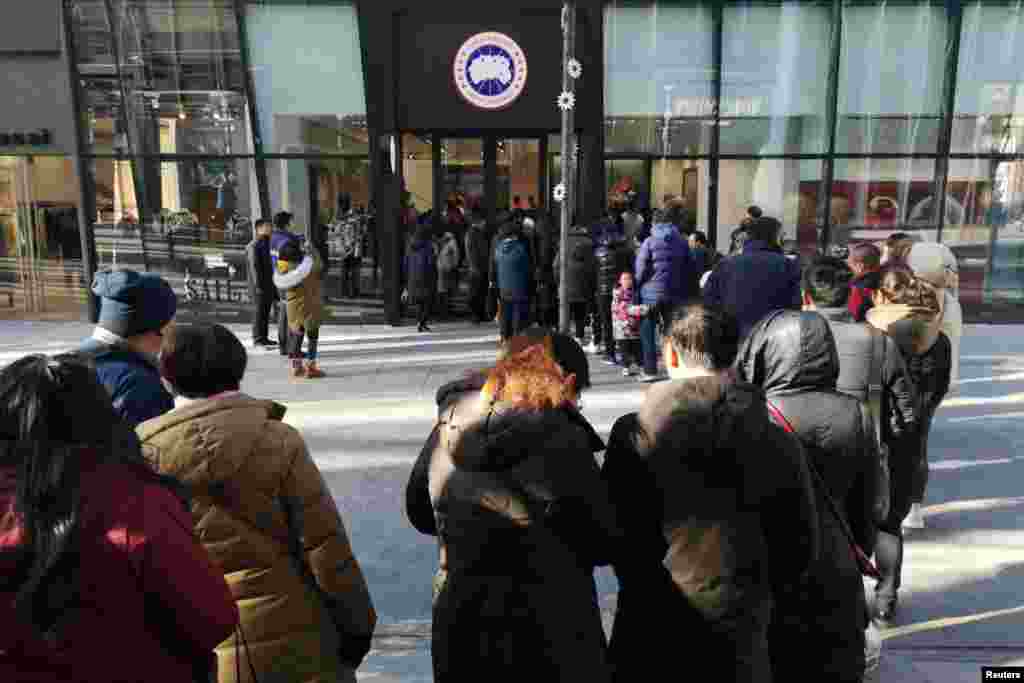 顾客在北京三里屯刚刚开张的加拿大鹅牌旗舰店外排起长队(2018年12月30日)。 虽然中国和加拿大最近关系紧张,但是“加拿大鹅”在中国仍然一鸣惊人。路透社报道,这个加拿大奢侈品牌的外衣店开张后的第一个周一下午,门外的顾客起码要在严冬中排队长达一个小时才能踏进店门。店内销售的连帽大衣的价格能最高达到9000人民币。这说明曾经导致它推迟开业的那种“抵制加货”的呼吁后来没有奏效。