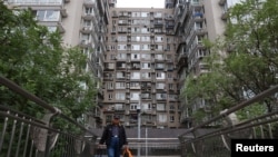 一名男子走过北京一座住宅楼旁的人行天桥。(2024年10月17日)