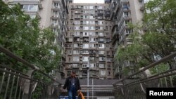 一名男子走过北京一座住宅楼旁的人行天桥。(2024年10月17日)