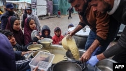 资料照片:志愿者向加沙地带南部拉法的流离失所的巴勒斯坦人分发食物。(2024年2月18日)