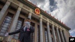 资料照:一名中国保安官员在正在举行全国人大会议的北京人大会堂外警卫。(2020年5月25日)