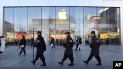 一队保安从北京一家苹果商店前走过。(2019年3月6日)