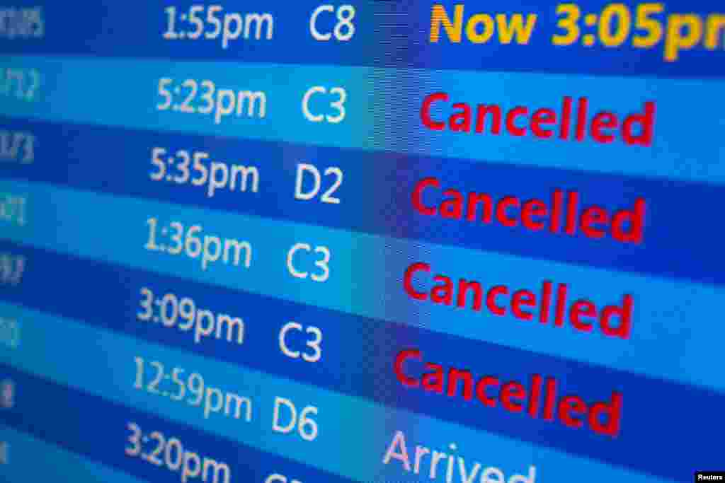 Cancelled flights are displayed on a status board at New York's Laguardia Airport ahead of a powerful approaching winter storm, Jan. 22, 2016.