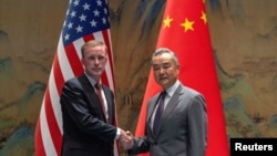 中共中央外事工作委员会办公室主任王毅在北京雁栖湖与到访的美国白宫国家安全顾问杰克·沙利文握手。(2024年8月27日)