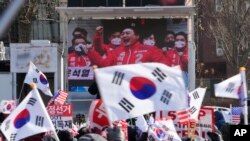 韩国总统尹锡悦的支持者2025年1月7日在总统官邸附近举行集会,大屏幕上显示尹锡悦的资料图像。