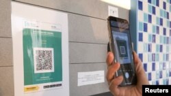 在新冠病毒爆发后,香港一家购物中心张贴了“安心出行“追踪应用程序的二维码 (路透社照片)