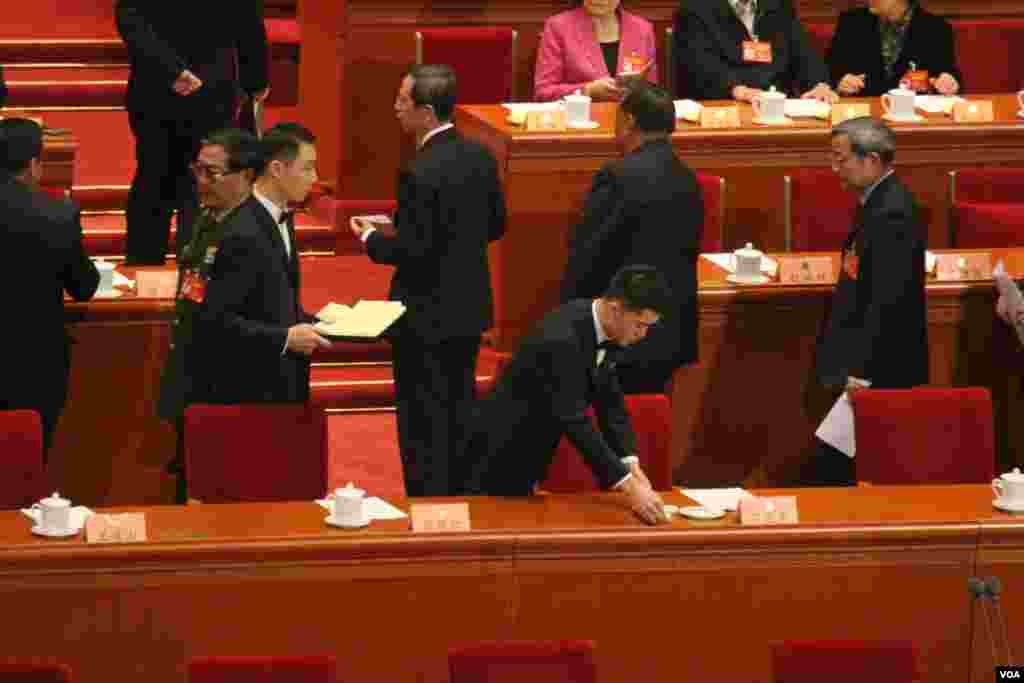 2017年3元13日， 政协闭幕会前，服务员为习近平坐位摆放毛巾(美国之音叶兵，艾伦拍摄)