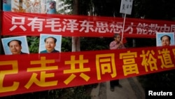 资料照：中国毛派人士手举毛泽东画像和标语横幅在广州南方周末报社外举行抗议集会。（2013年1月9日）