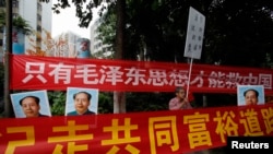 资料照:中国毛派人士手举毛泽东画像和标语横幅在广州南方周末报社外举行抗议集会。(2013年1月9日)