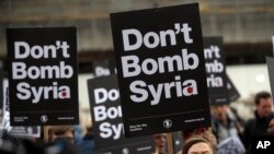 Protesters take part in a small demonstration organized by the Stop the War Coalition against possible military intervention or bombing by western allies in Syria, in London, April 13, 2018.
