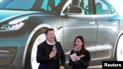 特斯拉执行总裁马斯克和特斯拉中国区高管陶琳在上海举行的国产特斯拉Model 3型汽车交付仪式上。(2021年1月7日)