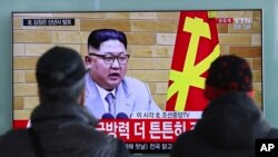 South Koreans watch a TV news program showing North Korean leader Kim Jong Un's New Year's speech, at the Seoul Railway Station in Seoul, South Korea, Jan. 1, 2018.