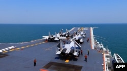 资料照:中国海军舰队在东中国海举行了“实弹演习”期间,航空母舰辽宁号上载有的歼15战机。(2018年4月24日)