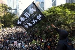 香港一名示威者在抗议游行期间挥舞“光复香港 时代革命”的旗帜。(2019年11月30日)