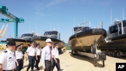 美国驻河内大使馆公布的这张照片显示,美国大使泰德·奥索斯(中)与越南海岸警卫队人员在2017年5月22日在越南中部广南举行的转交仪式中一道视察美国送交的“金属鲨鱼”巡逻艇。