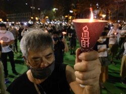 参与六四31周年维园烛光集会的市民高举烛光,为六四屠城死难者默哀一分钟 (美国之音/汤惠芸)