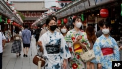 日本东京一条购物街上身穿传统和服的日本姑娘。(2021年8月13日)