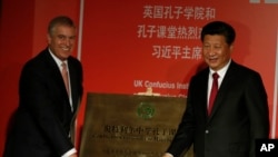 资料照:中国领导人习近平在伦敦与英国安德鲁王子为一个孔子学院开幕揭牌。(2015年10月22日)