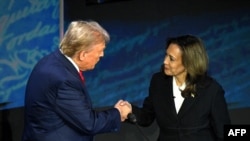 2024年9月10日,美国副总统兼民主党总统候选人卡玛拉·哈里斯(Kamala Harris)(右)在宾夕法尼亚州费城国家宪法中心举行的总统辩论中与美国前总统、共和党总统候选人唐纳德·特朗普(Donald Trump)握手。(索尔·勒布/法新社拍摄)