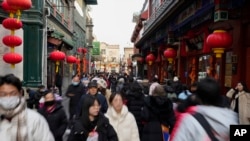 游人和居民春节前在北京一条购物街逛街。(2025年1月23日)