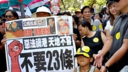 资料照:香港民众举着反对“恶法”的标语准备参加反对23条立法的大游行(美联社2003年7月1日)