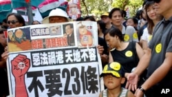 资料照:香港民众举着反对“恶法”的标语准备参加反对23条立法的大游行。(2003年7月1日)
