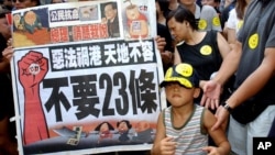 资料照:香港民众举着反对“恶法”的标语准备参加反对23条立法的大游行。(2003年7月1日)