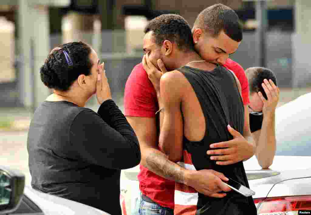Friends and family members embrace outside the Orlando Police Headquarters during the investigation of a shooting at the Pulse night club, in Orlando, Florida, June 12, 2016.