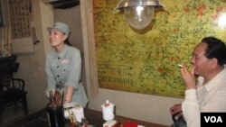 在中共革命胜地西柏坡,一名扮演毛泽东的特型演员等待与游客合影,一名穿着八路军服的女子在一旁收费。(2013年)