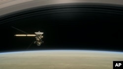 This image made available by NASA in April 2017 shows a still from the short film "Cassini's Grand Finale," with the spacecraft diving between Saturn and the planet's innermost ring.