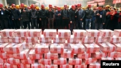 资料照片:农民工在中国陕西西安一处建筑工地等待领取春节前的工资和奖金。(2017年1月18日)